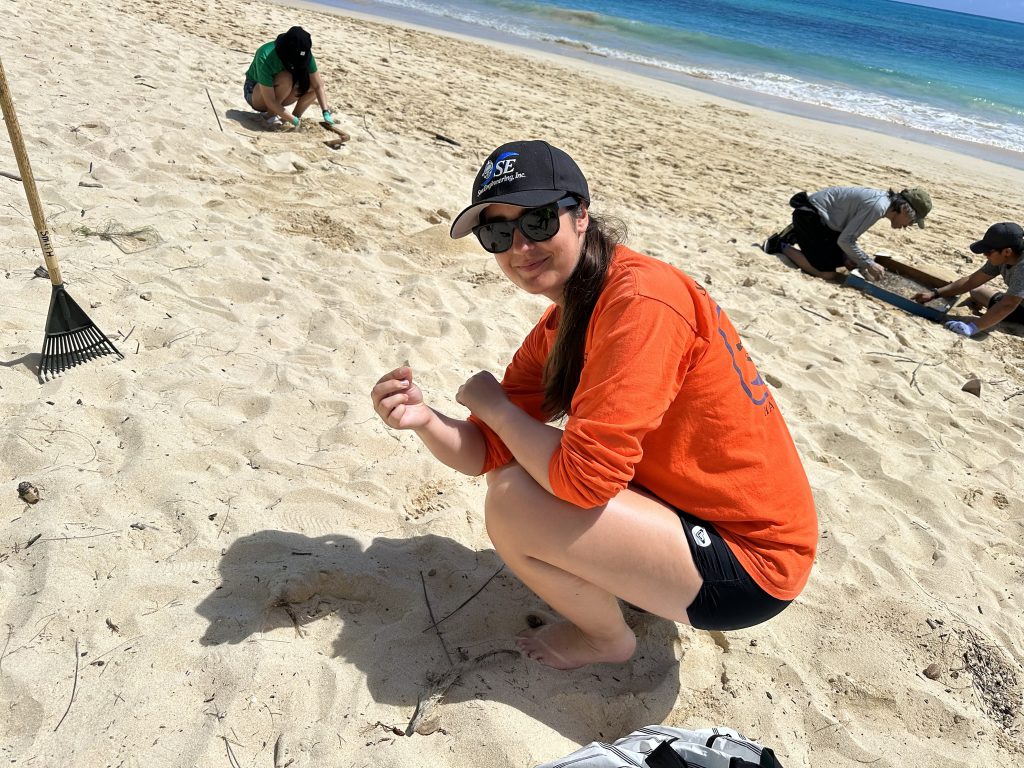 volunteer picture holding plastic. Honolulu Post volunteers support microplastics beach cleanup to celebrate Earth Day in April.
