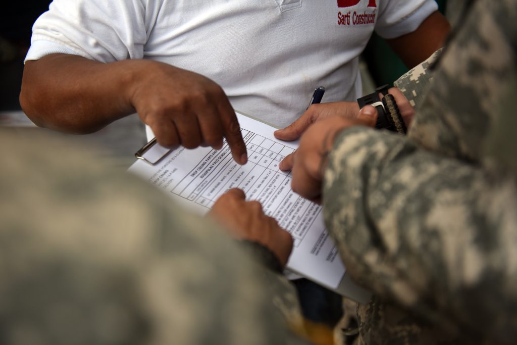 Palo Gordo, Guatemala—U.S. Army Spc. Robert Gutierrez, (Left) 578th Brigade Engineer Battalion combat engineer, U.S. Army Staff Sgt. Shaun Rase, (Right) 1038th Engineer Company engineer and Oliverio Cahuec, Guatemala construction material supplier debate over the quantity of items delivered during Exercise BEYOND THE HORIZON 2016 GUATEMALA April 27, 2016. As a newly appointed contract officer representative Rase is responsible verifying all delivered construction items.